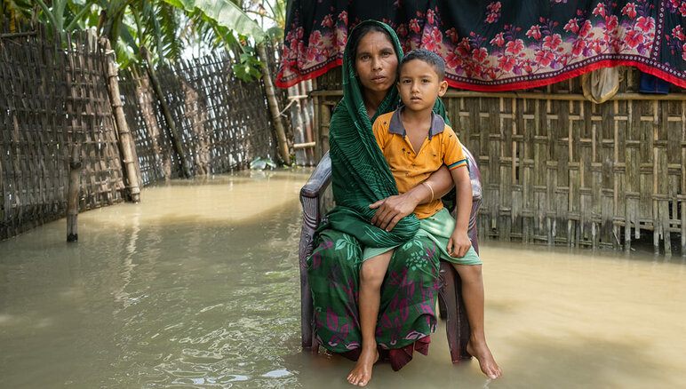باران های موسمی شدید در جولای 2020 نواحی شمالی و شمال شرقی بنگلادش را درگیر سیل کرد. سیل خانه سایما را غرق کرده و زندگی عادی را برای او بسیار دشوار کرده است. او و خانواده اش از کمبود غذا رنج می‌برند. برنامه جهانی غذا به تقریباً 6 هزار خانواده در کوریگرام که آسیب پذیرترین و نیازمندتر هستند کمک نقدی ارائه می دهد. برنامه جهانی غذا / مهدی رحمان 