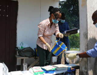 Louise Abayomi, Senior Research Fellow (Postharvest), Food and Markets Department, preparing fufu to be sampled and showing the Congolese team how to dose the right amount of flour, water, nutrients. Photo: WFP/Alice Rahmoun