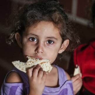 دختری در حال خوردن نان. عکس: برنامه جهانی غذا/علی جداالله